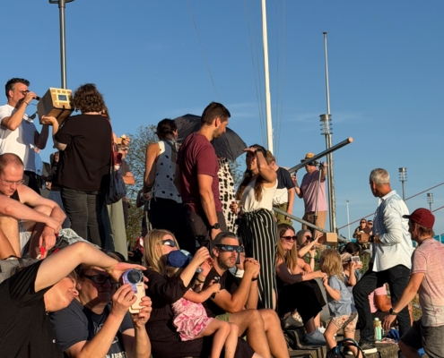 Gespanntes Warten am Deich Zahlreiche Schüler, Lehrkräfte und Gäste versammeln sich beim Bootshaus des GTRVN